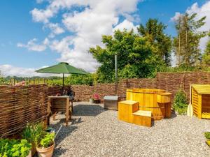 a patio with an umbrella and a wooden fence at 1 Bed in Canterbury oc-88795 in Chillenden