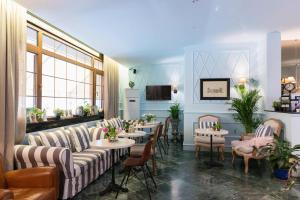 a restaurant with couches and tables and chairs at Areela Boutique Hotel in Tirana
