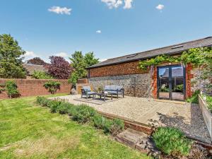 a garden with a patio and a brick building at 1 Bed in Chichester oc-77402 in Eastergate