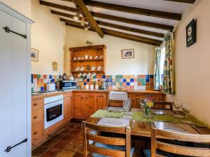 a kitchen with a wooden table and chairs and a table and a kitchen with at 2 Bed in Kings Lynn oc-77765 in Tattersett +5 photos