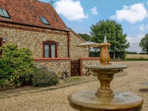 a fountain in front of a house with a building at 2 Bed in Kings Lynn oc-77765 in Tattersett