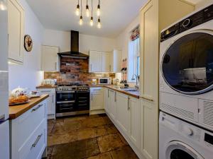 a kitchen with white cabinets and a washer and dryer at 3 Bed in Bognor Regis oc-83115 in Bognor Regis +10 photos
