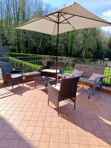 a patio with chairs and an umbrella and a table at Casa Fiocco vista Lago in Pisogne