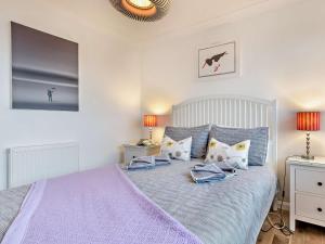 a bedroom with a bed with purple sheets and pillows at 2 Bed in Norwich oc-75391 in Bacton