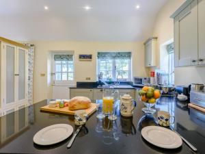 a kitchen with a table with plates and a loaf of bread at 1 Bed in Lewes oc-79182 in Beddingham