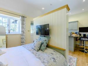 a bedroom with a bed with a tv on the wall at 1 Bed in Lewes oc-79182 in Beddingham