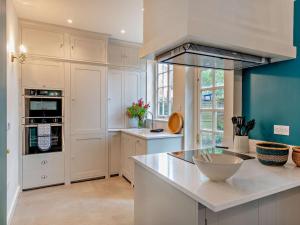 a kitchen with white cabinets and a blue wall at 3 Bed in Colchester oc-94016 in Dedham +14 photos