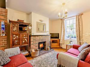 a living room with a fireplace and a red couch at 2 Bed in Arundel oc-89671 in Arundel