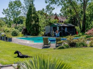 a dog laying in the grass next to a pool at 2 Bed in Uckfield oc-80504 in Framfield