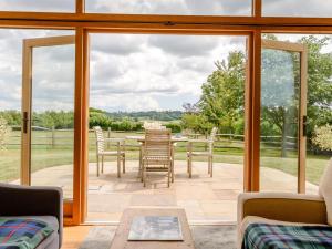 a conservatory with sliding glass doors and a table and chairs at 1 Bed in Cranbrook oc-76565 in Rolvenden