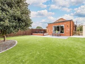a garden with a brick house with a lawn at 2 Bed in Mablethorpe oc-93143 in Trusthorpe