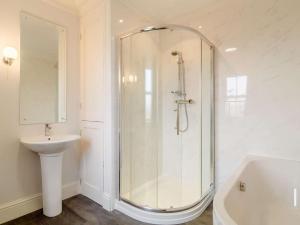 a white bathroom with a shower and a sink at 5 Bed in Wisbech oc-90134 in Wisbech +29 photos