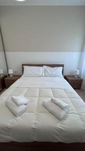 a large white bed with two white towels on it at Casa Memi in Chioggia