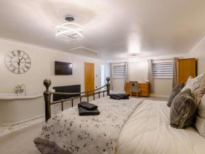 a bedroom with a bed and a clock on the wall at 4 Bed in Norwich oc-90094 in Stratton Strawless