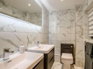 a bathroom with a sink and a toilet and a mirror at 4 Bed in Norwich oc-90094 in Stratton Strawless +16 photos