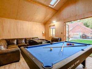 a living room with a pool table and a couch at 4 Bed in Norwich oc-90094 in Stratton Strawless