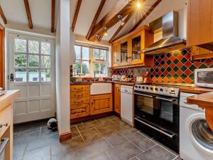 a kitchen with wooden cabinets and a stove top oven at 3 Bed in Norwich oc-85528 in Thurgarton