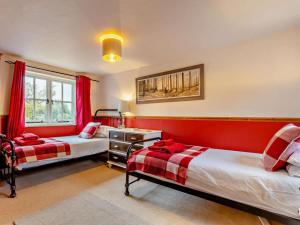 two beds in a room with red walls at 3 Bed in Norwich oc-85528 in Thurgarton