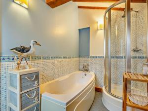 a bathroom with a bath tub and a bird on a counter at 3 Bed in Norwich oc-85528 in Thurgarton +12 photos