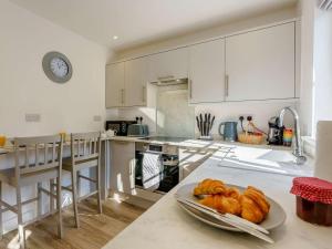 a kitchen with white cabinets and a plate of bread at 1 Bed in Broadstairs oc-89391 in Broadstairs +6 photos