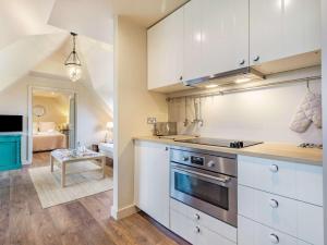 a kitchen with white cabinets and a stove top oven at 1 Bed in Horsham oc-86961 in Rudgwick