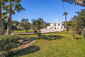 a yard with palm trees and a house at Casa Jardim in Loulé
