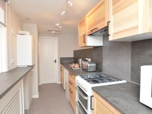 a kitchen with wooden cabinets and a stove top oven at 2 Bed in Boston oc-90123 in Boston