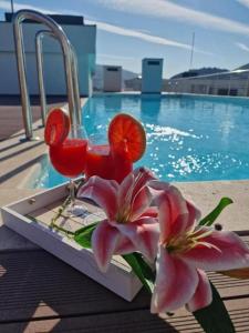 a table with two cocktails and flowers next to a pool at NOIR Luxury in Trebinje