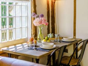 a wooden table with a vase of flowers on it at 1 Bed in Ashford oc-82527 in Biddenden