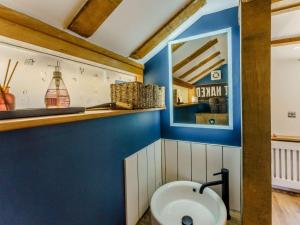 a bathroom with a sink and a blue wall at 1 Bed in Ashford oc-82527 in Biddenden