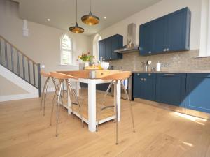 a kitchen with blue cabinets and a wooden table at 2 Bed in Alford oc-42581 in Ulceby +7 photos