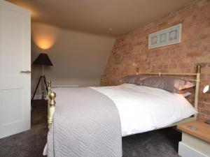 a bedroom with a bed with a brick wall at 2 Bed in Alford oc-42581 in Ulceby