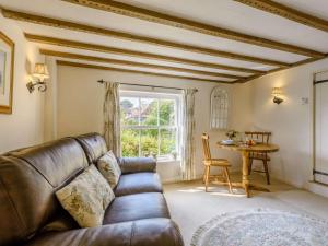 a living room with a leather couch and a table at 1 Bed in Battle oc-83845 in Sedlescombe
