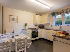a kitchen with white cabinets and a table with chairs at 2 Bed in Colchester oc-42650 in Dedham