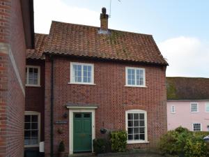 a red brick house with a green door at 2 Bed in Colchester oc-42650 in Dedham