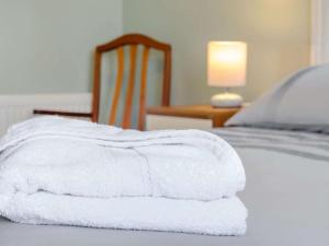 a stack of white towels sitting on a bed at 1 Bed in Broadstairs oc-89359 in Broadstairs