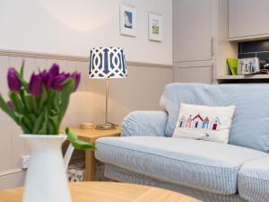 a living room with a blue chair and a vase with purple flowers at 3 Bed in Eastbourne oc-ehc38 in Eastbourne