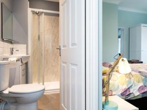 a bathroom with a toilet and a shower and a bed at 3 Bed in Eastbourne oc-ehc38 in Eastbourne