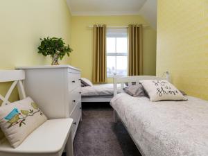 a bedroom with two beds and a chair and a window at 3 Bed in Eastbourne oc-ehc38 in Eastbourne