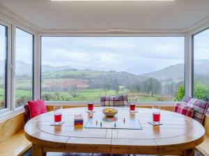 a table with two chairs in front of a large window at 4 Bed in Keswick oc-86250 in Threlkeld +15 photos