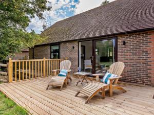 a wooden deck with two chairs and a table at 2 Bed in Hailsham oc-89416 in Hailsham