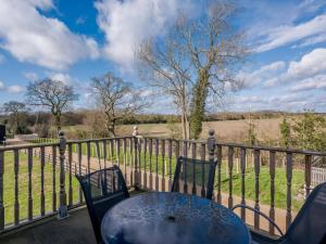 a table and chairs on a balcony with a view of a field at 3 Bed in Dereham oc-65903 in Foulsham