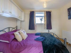 a purple bed in a room with a window at 3 Bed in Dereham oc-65903 in Foulsham