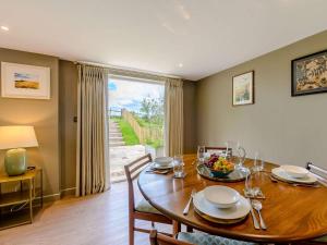 a dining room with a wooden table and a large window at 1 Bed in Battle oc-88029 in Brightling