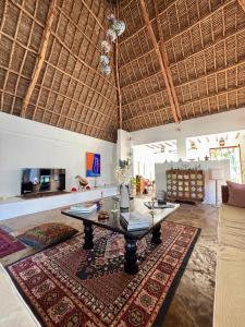 a living room with a table and a rug at Flower House in Malindi