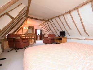 a bedroom with a bed and two chairs and a television at 2 Bed in Bedford oc-62322 in Wyboston