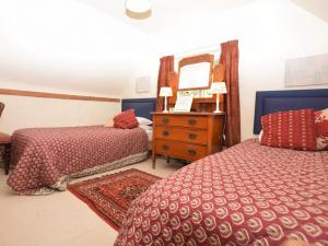 a bedroom with two beds and a dresser with a mirror at 2 Bed in Bedford oc-62322 in Wyboston