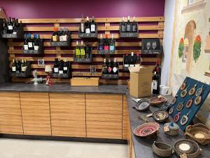 a store with a counter with bottles of wine at Flower Camping de L Olivigne in Bize-Minervois