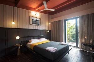 a bedroom with a bed and a ceiling fan at East India House in Gorai