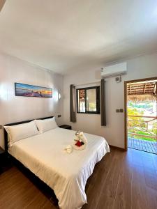 a bedroom with a bed with a bowl of fruit on it at Holiday Beach Hotel in Nosy Be